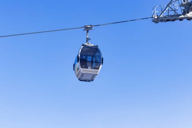 Mavi gökyüzünün arka planında kabin teleferik