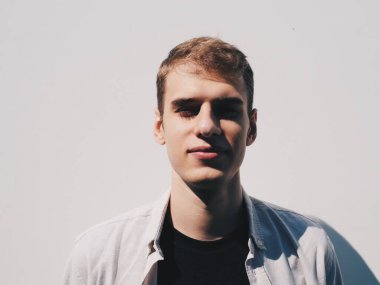 Arkadaki beyaz duvardaki yakışıklı, şık, sarışın adam.