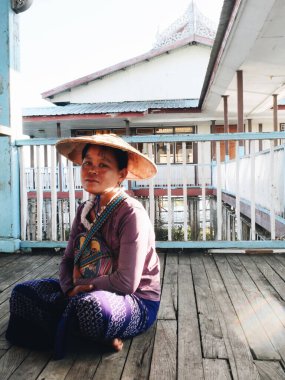 Inle Lake, Myanmar 24 Şubat 2020 - Geleneksel kıyafetler ve hasır şapkalı kadın portresi. Dikey fotoğraf