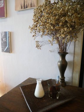 Buzlu kahve ve ahşap tepside küçük süt sürahisi.