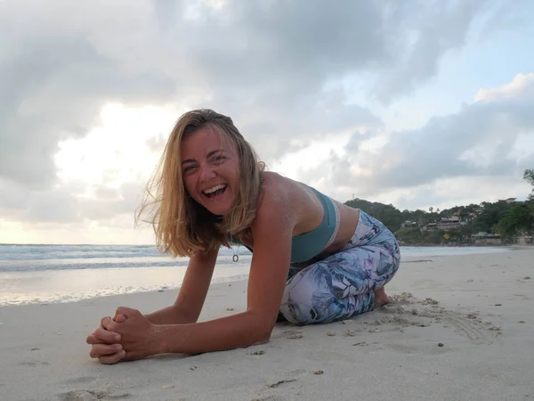 Jovem menina branca sorridente em sportswear prática de ioga à beira-mar — Fotografia de Stock