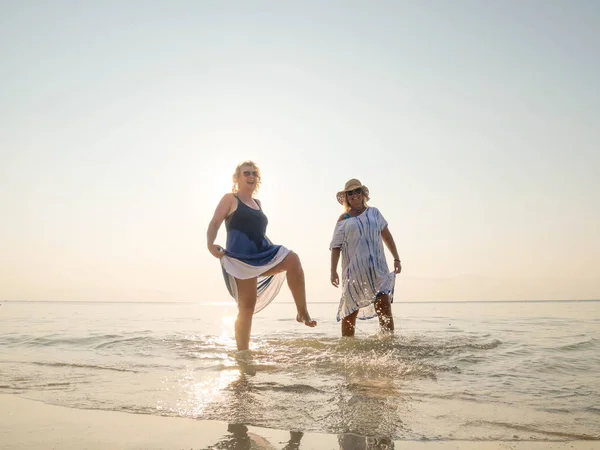 Δύο Αστείες Μεγαλύτερες Γυναίκες Στέκονται Στο Νερό Στην Ακτή Ηλιόλουστη — Φωτογραφία Αρχείου