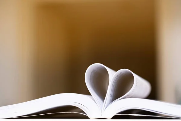 Pages of a book curved into a heart shape background