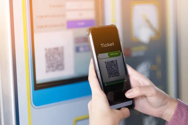 Девушка сканирует QR-код, чтобы купить билет на поезд — стоковое фото