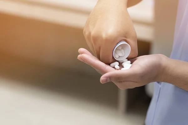 Een patiënt neemt een aantal witte pillen bij de hand voor behandeling — Stockfoto