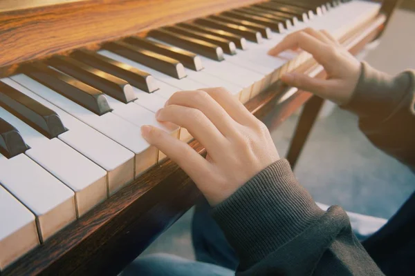 En kvinna som spelar piano i sitt rum — Stockfoto