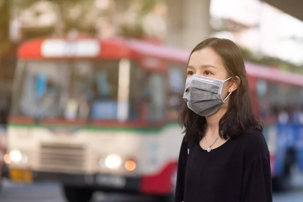 Viaggiatori asiatici ragazza con maschera medica per proteggere il coronavirus sulla strada nella città di Bangkok — Foto Stock