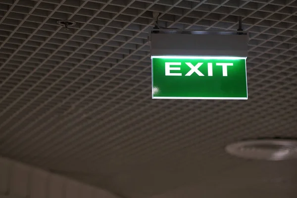 Green light fire exit sign in office building — Stockfoto