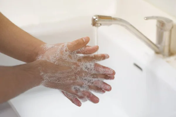 A man washed his hands with soap in a sink