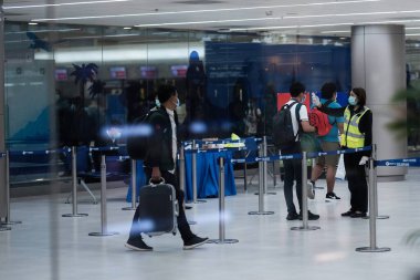 Donmuang Havaalanı, Bangkok, Tayland 'da 18 Mart 2019' da gezgin vücut ısısını ölçen bir personel.