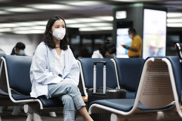 Asian travelers girl with surgical face mask to protection the covid-19 in airport