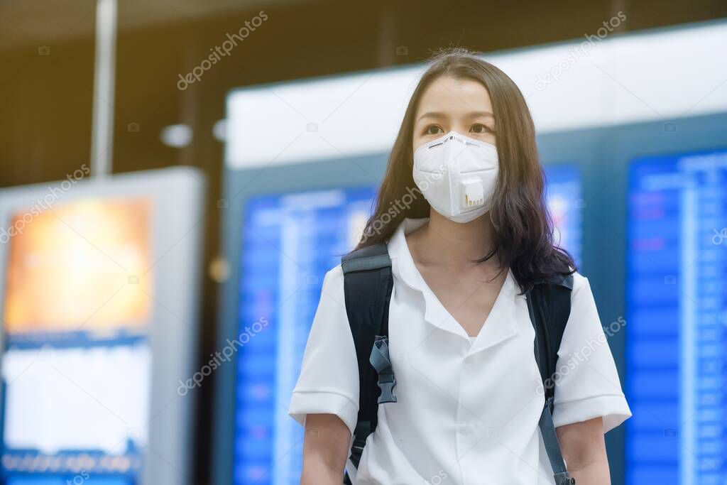 Asian travelers girl with surgical face mask to protection the covid-19 in airport