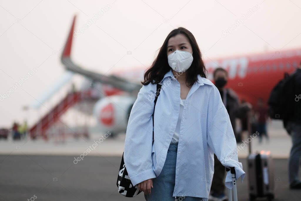 Asian travelers girl with surgical face mask to protection the covid-19 in airport