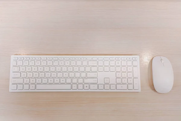 White keyboard and mouse on wood background