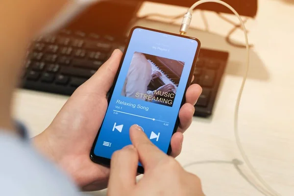 A man listening Music streaming application on smartphone