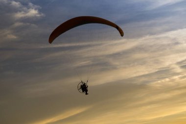 Paraglider renkli günbatımında havada uçuyor. Slovakya