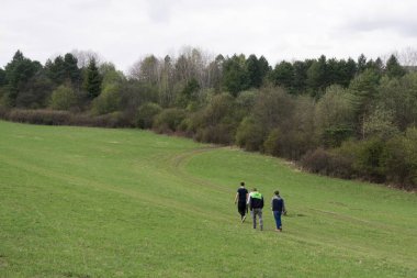 Tarlada yürüyen insanların olduğu bir manzara.