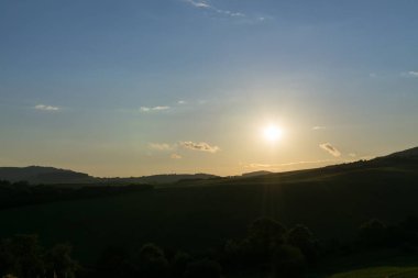 Mavi gökyüzü ve yeşil ağaçlı çayırların gündüz görüntüsü