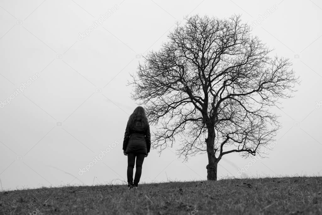 silhouette of woman in standing alone near tree