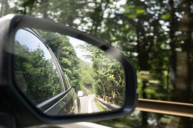 Güzel manzara araba aynasına yansıyor.