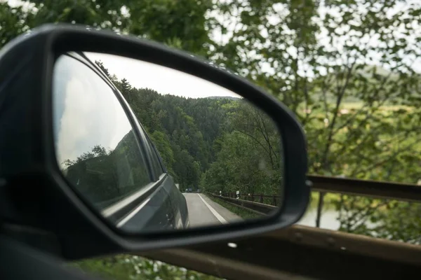 beautiful landscape reflect in mirror of car