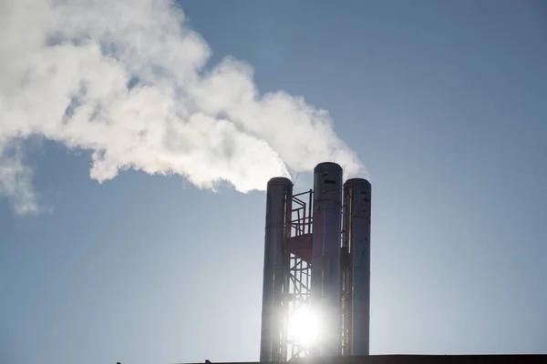 Factory pipes on sky background