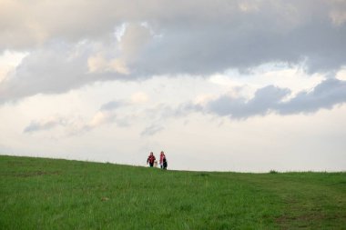Gün batımında vadide köpeklerle yürüyen iki kadın.