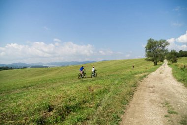 Yeşil alanda dağ bisikleti süren insanlar