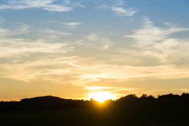 Arkaplanda bulutlarla gökyüzünde gün batımı