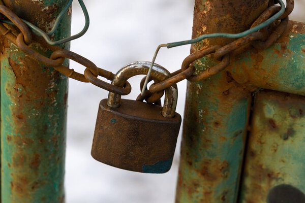 Ржавый замок на воротах в заборе. Словакия