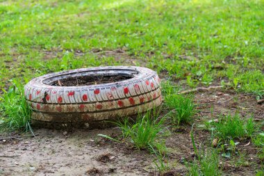 Araba tekerleği ve çimenlerin eski lastiği.