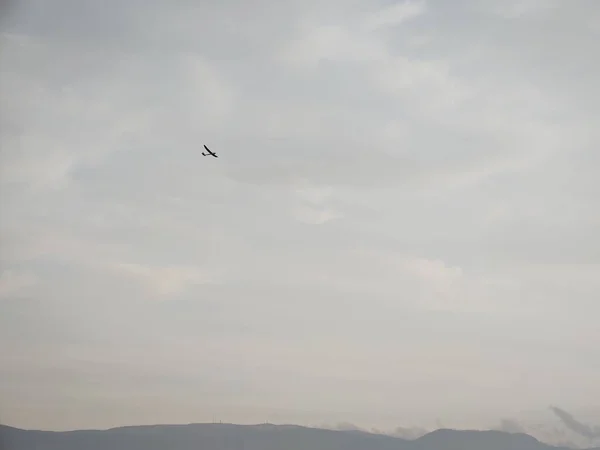 飞机在多云的天空中飞越山丘的风景 — 图库照片