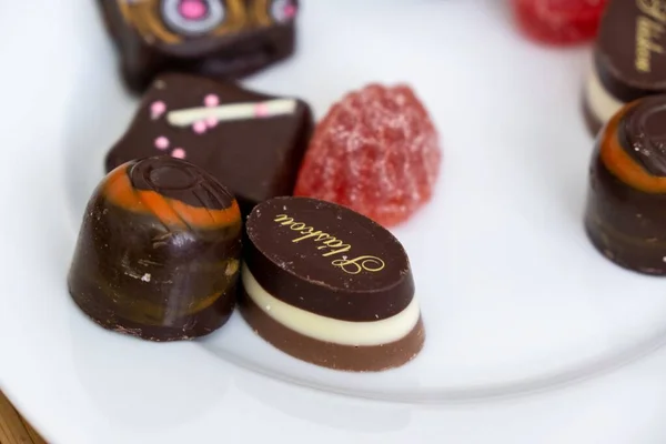 ホワイトプレートで出されるチョコレートキャンディーやお菓子 — ストック写真