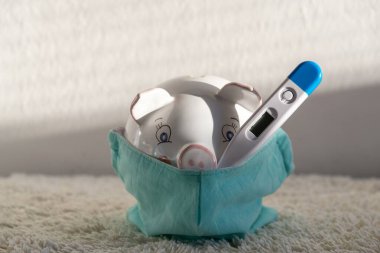 Termometresi solunum maskeli domuz kumbarası salgın sırasında ekonomik sorunları ve finansal tasarrufları gösteriyor. Slovakya