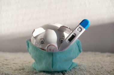 Termometresi solunum maskeli domuz kumbarası salgın sırasında ekonomik sorunları ve finansal tasarrufları gösteriyor. Slovakya