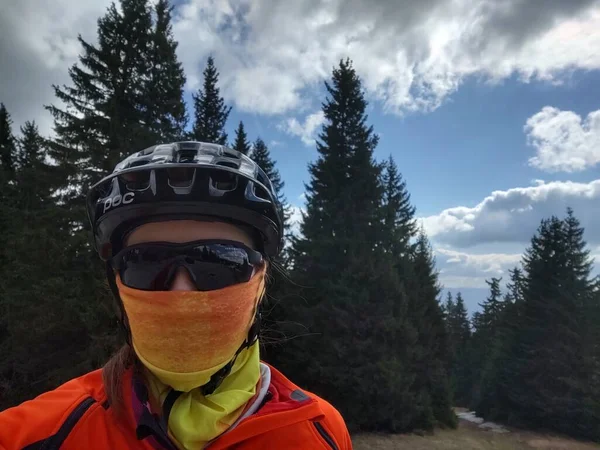 Cyclist Woman with helmet and sunglasses in the respirator mask in the nature. Slovakia
