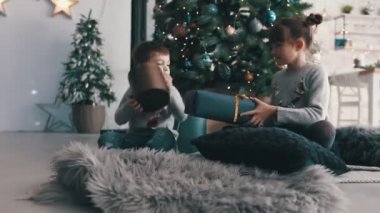 Mutlu çocuklar hediye kutularıyla paylaşıyorlar. Tahmin et içinde ne var.