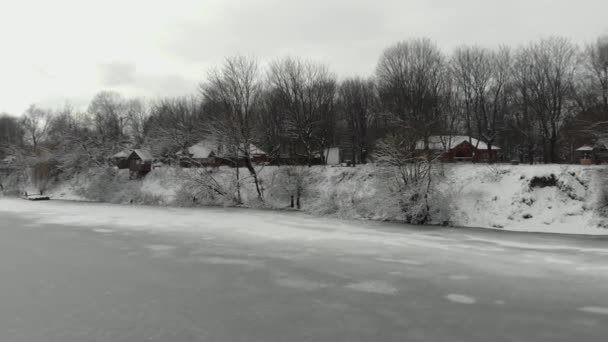 Zima u břehu řeky s obytnými domy — Stock video