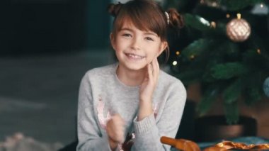 Gülümseyen küçük kız Noel ağacının yanında