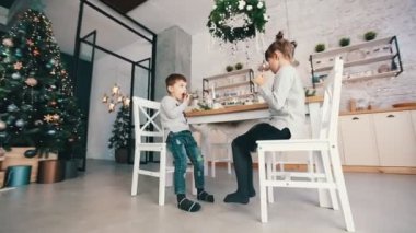 Çocuklar yemek odasında kurabiye tadıyor.