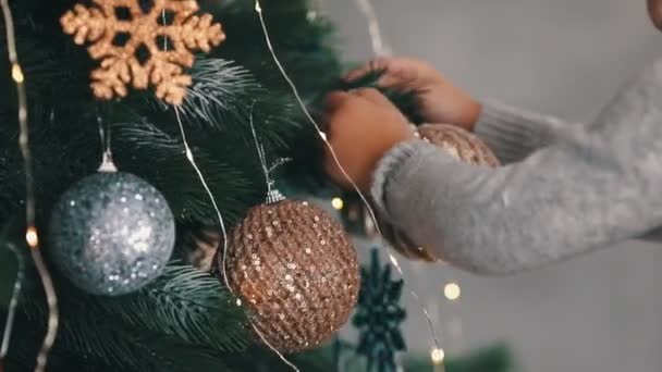 Close up slove motion boy pendurando um brinquedo em uma árvore de natal — Vídeo de Stock