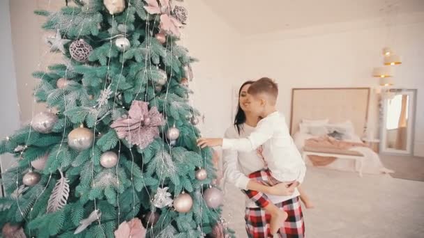 Gelukkig familie versieren kerstboom in witte kamer — Stockvideo