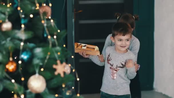 Mooi klein meisje vangen haar broer met cadeau — Stockvideo