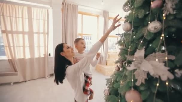 Mère montrer à son fils des jouets de Noël sur un sapin — Video