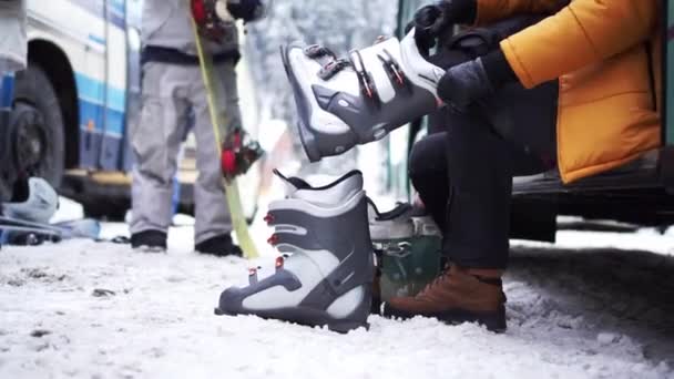 Muž vklouzne do bot na snowboardu. boční pohled — Stock video