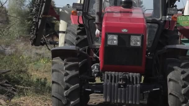 Zaparkowany czerwony traktor na podwórku. widok z przodu maski z kołami — Wideo stockowe