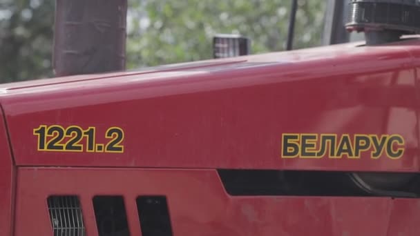 Vue latérale du tracteur rouge à la lumière du jour. gros plan — Video