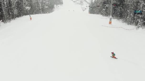 Snowboarder gaan van de piste in een skigebied. Bovenaanzicht — Stockvideo