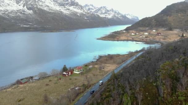 Piękny widok na drogę z samochodami w pobliżu jeziora z górami — Wideo stockowe
