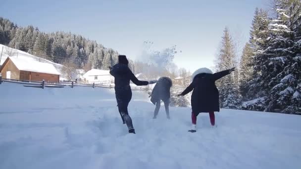 Жінки бігають через засніжений ліс і кидають жменьку снігу . — стокове відео